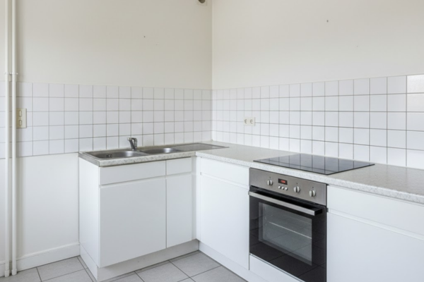 Cuisine d'appartement Paris après remise en état - murs blancs, surfaces brillantes, joints neufs