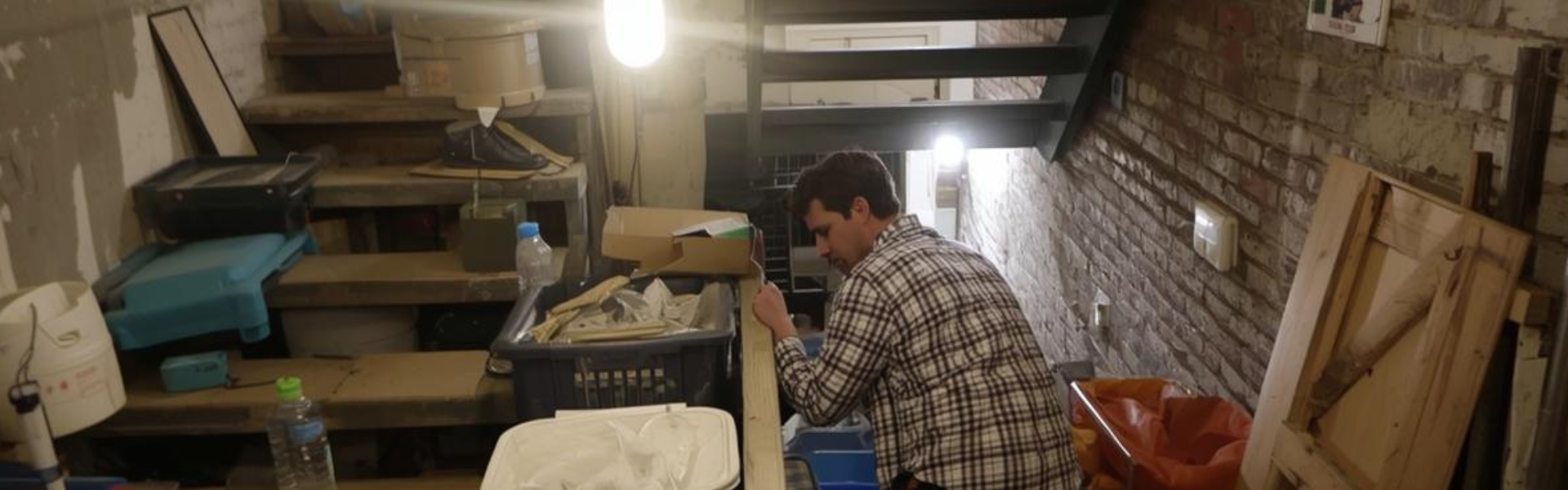Équipe OnLeveTout vidant une cave encombrée à Paris - débarras professionnel sous-sol avec escalier étroit immeuble haussmannien