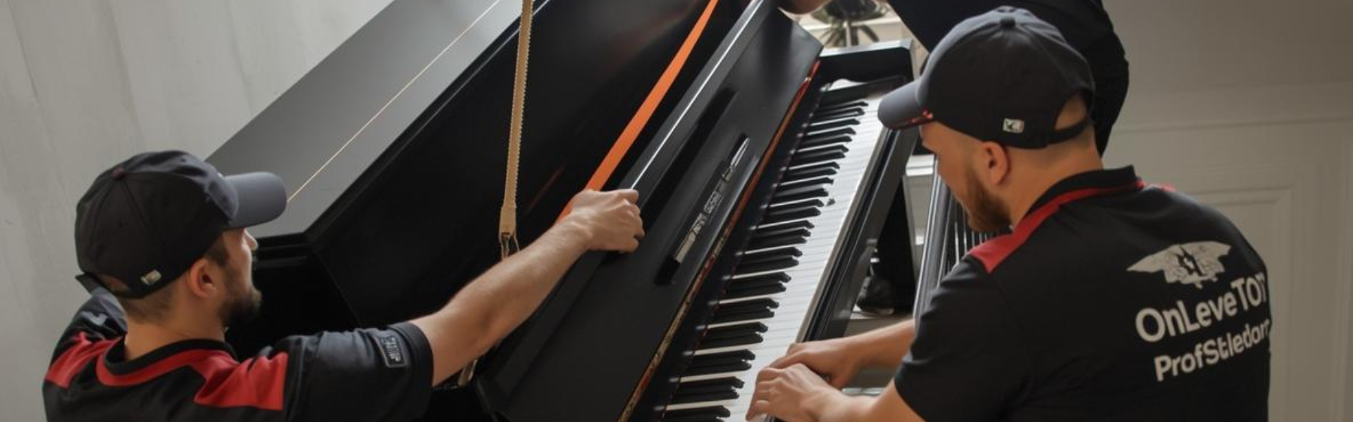 Débarras piano Paris - Enlèvement professionnel OnLeveTout 7j/7 Équipe professionnelle OnLeveTout de 3 déménageurs faisant un Débarras Piano Paris, un piano droit Yamaha noir dans un escalier parisien haussmannien avec sangles de sécurité professionnelles
