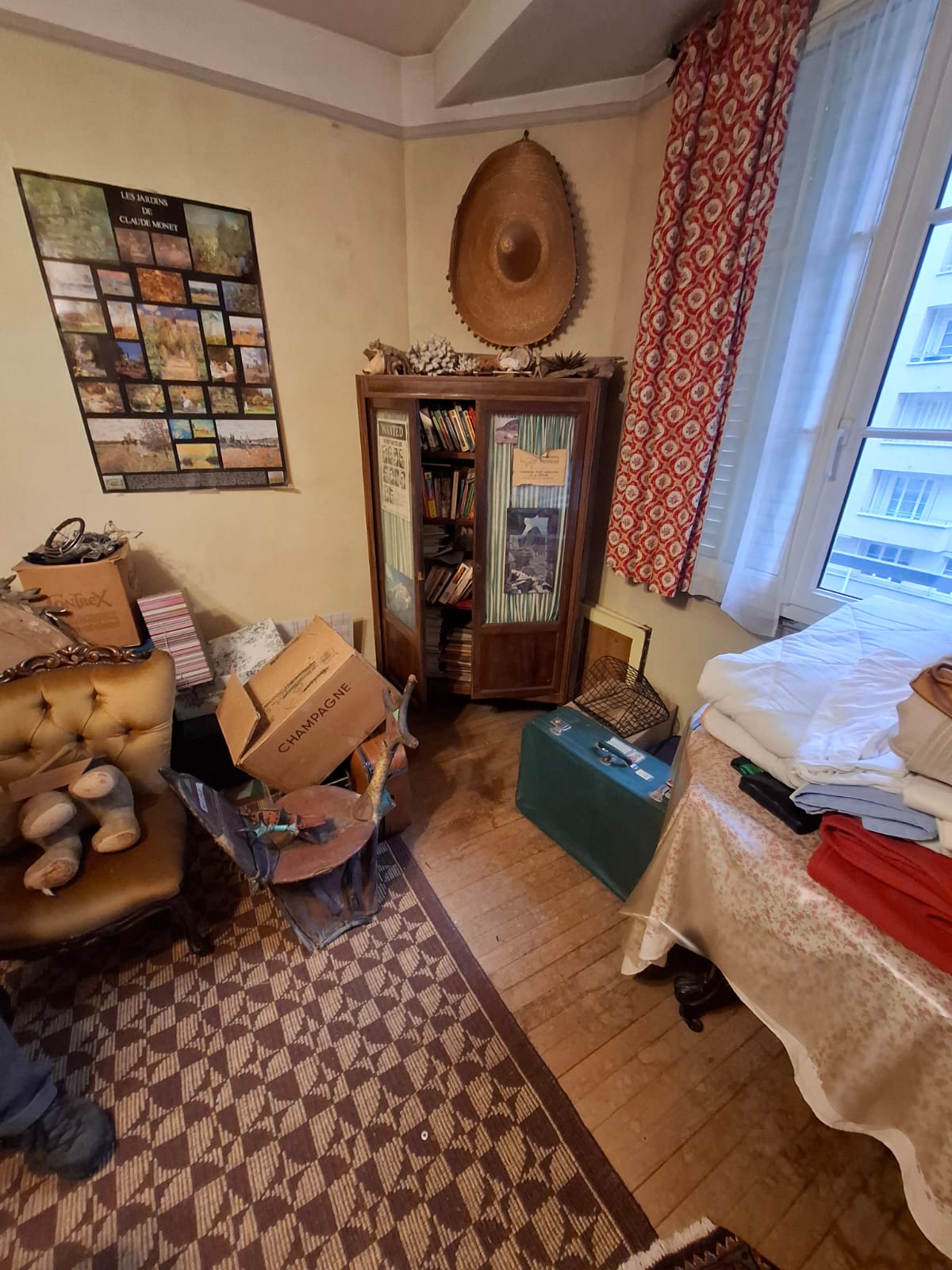Studio parisien de 18m² encombré avant intervention de débarras OnLeveTout - lit, armoire, cartons et effets personnels à évacuer dans chambre de bonne