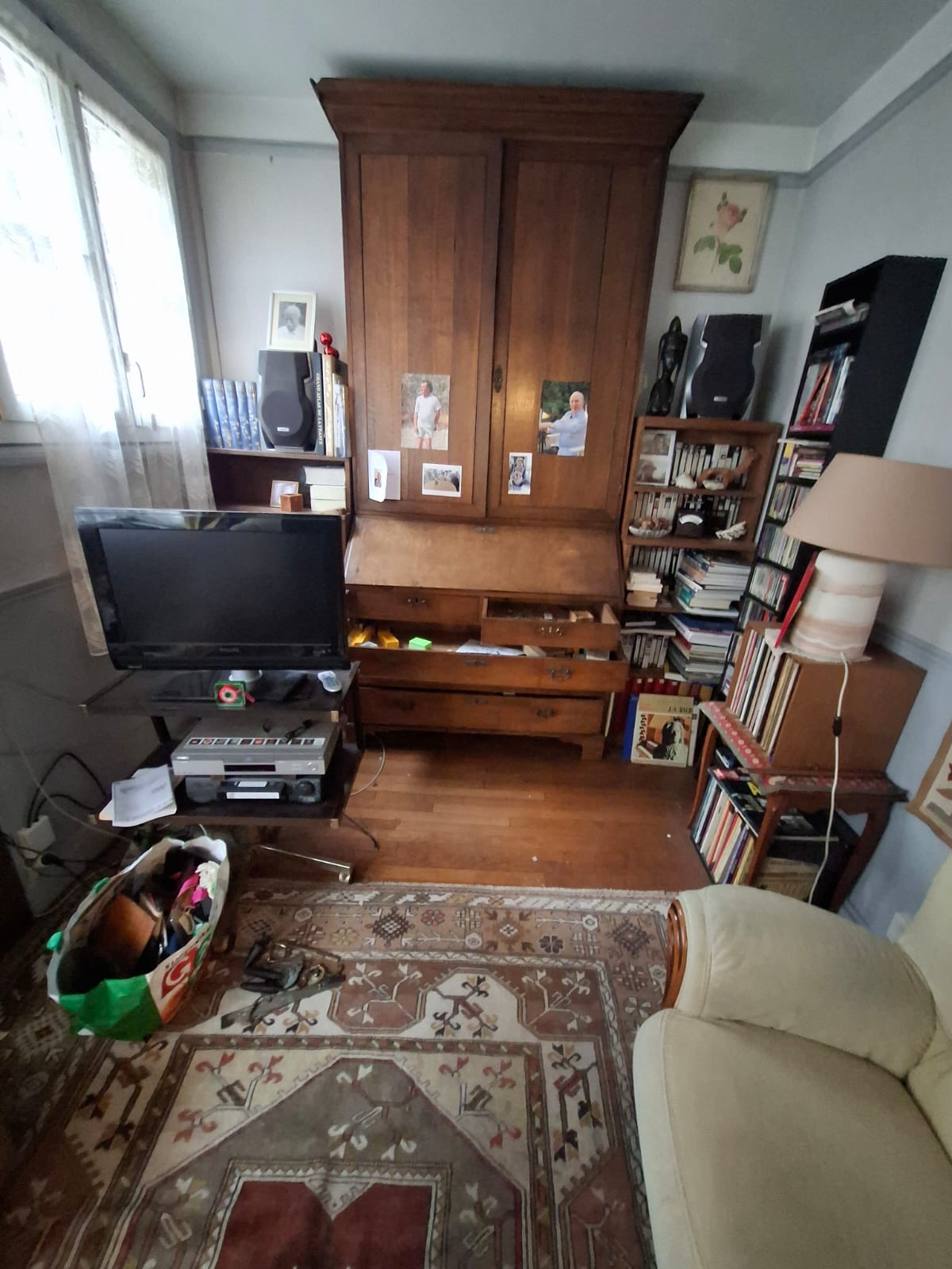 Appartement T2 parisien de 38m² à débarrasser - salon avec canapé et meuble TV, chambre encombrée de vêtements et cartons