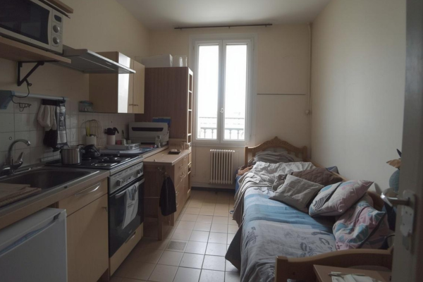 Petit studio 18m² à Paris avant débarras - kitchenette et coin nuit encombrés